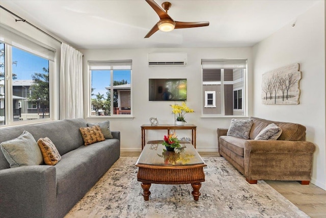 living room with a wall mounted air conditioner, ceiling fan, and light hardwood / wood-style floors