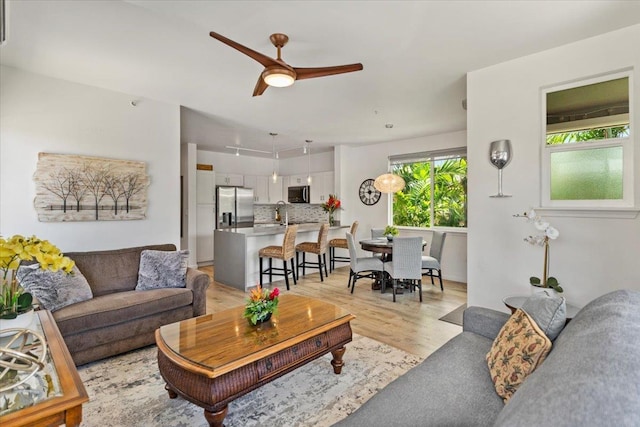 living room with light hardwood / wood-style flooring and ceiling fan