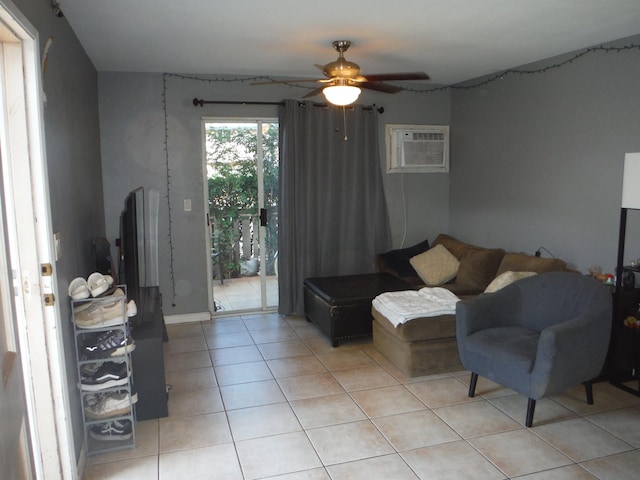 living room featuring light tile patterned floors, ceiling fan, and a wall unit AC