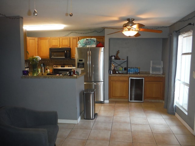 kitchen featuring light tile patterned floors, stainless steel appliances, tasteful backsplash, stone countertops, and beverage cooler