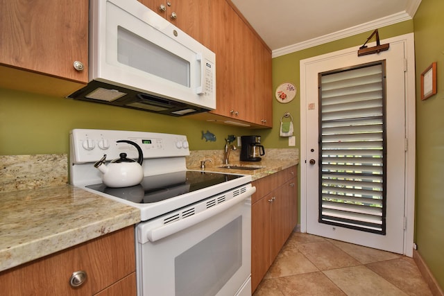 kitchen featuring crown molding, light tile patterned flooring, and white appliances