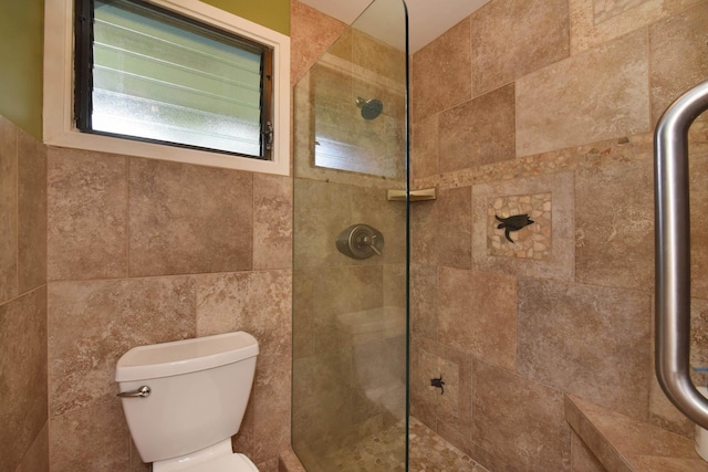 bathroom featuring toilet and a shower with shower door