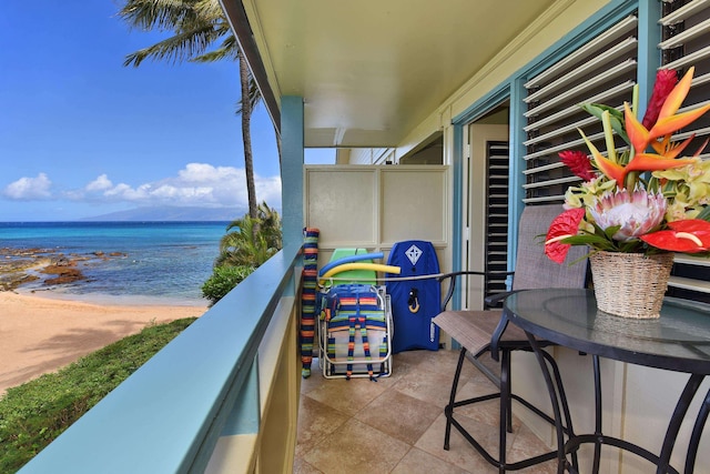 balcony featuring a water view and a beach view