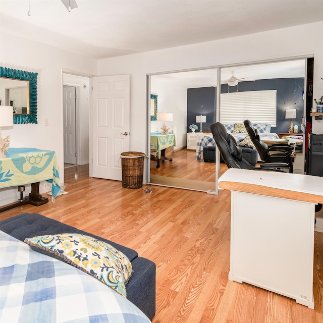 bedroom with ceiling fan, a closet, and light hardwood / wood-style floors