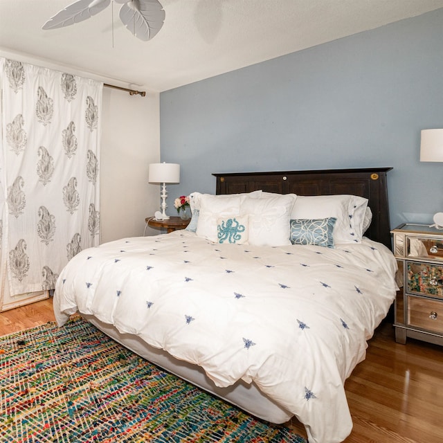 bedroom with ceiling fan and hardwood / wood-style flooring