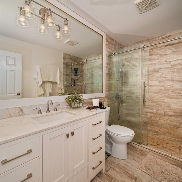 bathroom with vanity, toilet, and an enclosed shower