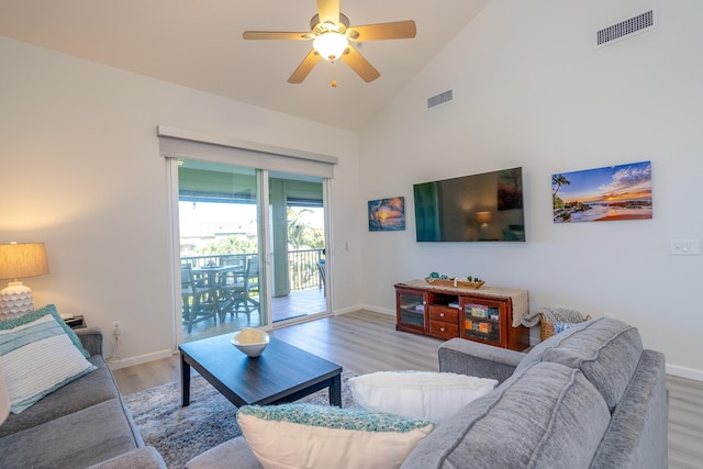 living room with ceiling fan, high vaulted ceiling, and light wood-type flooring