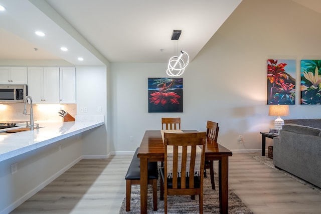 dining room with light hardwood / wood-style floors and sink