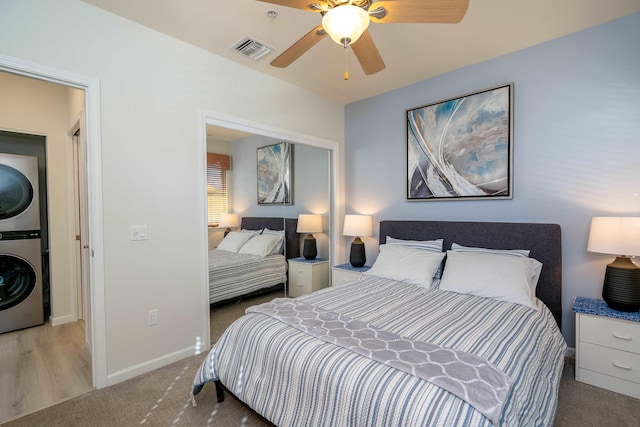 bedroom with stacked washer and dryer, carpet floors, and ceiling fan