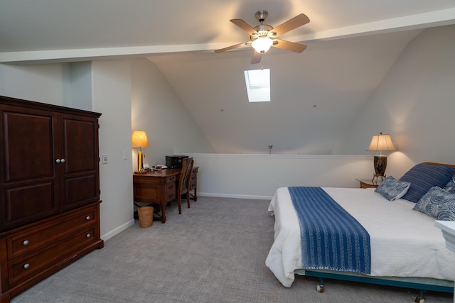 bedroom with ceiling fan, light colored carpet, and vaulted ceiling with skylight