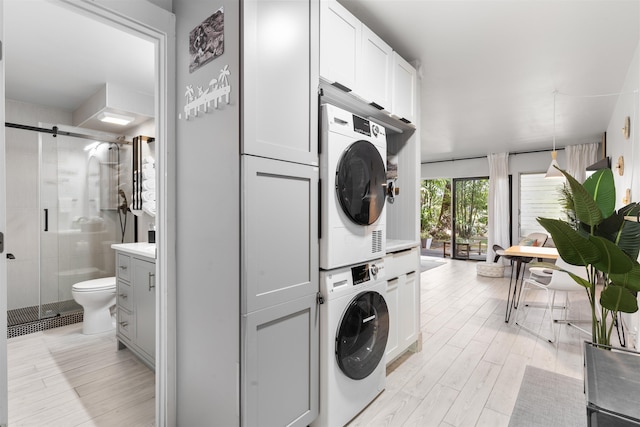 3559 Lower Honoapiilani Rd Unit 709, Lahaina, HI 96761 - laundry room with light wood-style flooring, stacked washing maching and dryer, and laundry area