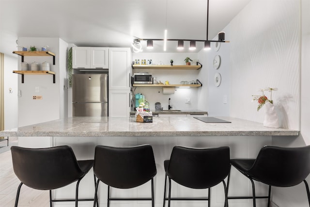 3559 Lower Honoapiilani Rd Unit 709, Lahaina, HI 96761 - kitchen featuring white cabinets, stainless steel appliances, a kitchen breakfast bar, light stone counters, and open shelves