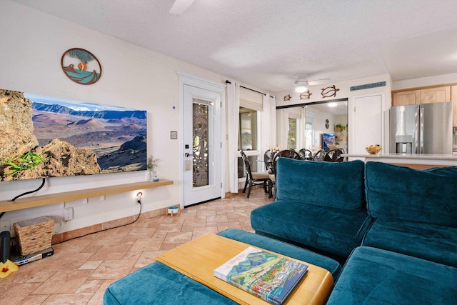 living room with a textured ceiling and ceiling fan