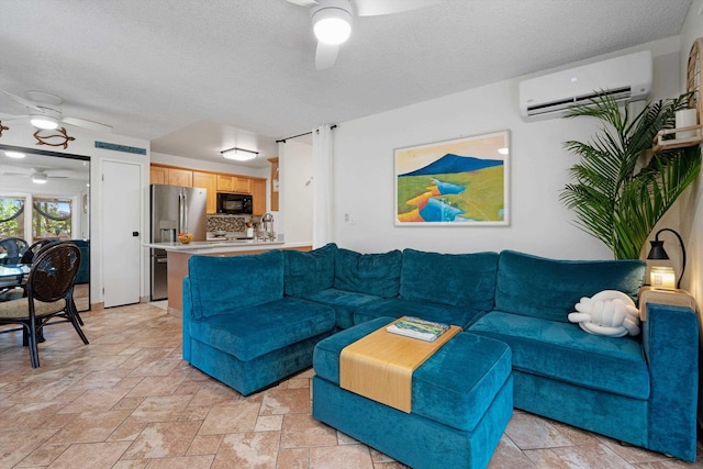 living room with ceiling fan, an AC wall unit, and a textured ceiling