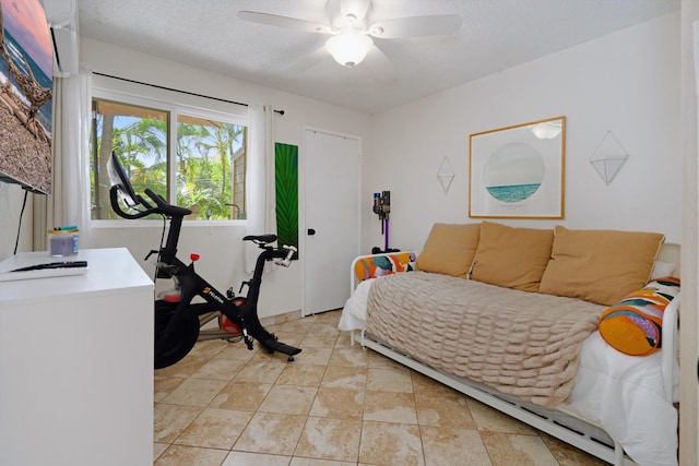 bedroom featuring light tile patterned floors, a textured ceiling, and ceiling fan