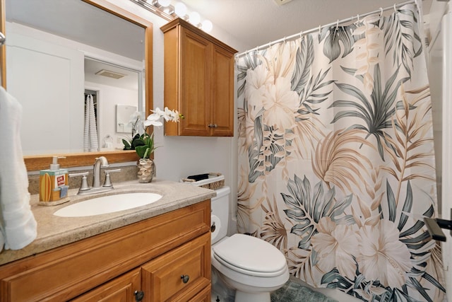 bathroom featuring vanity, toilet, and a textured ceiling