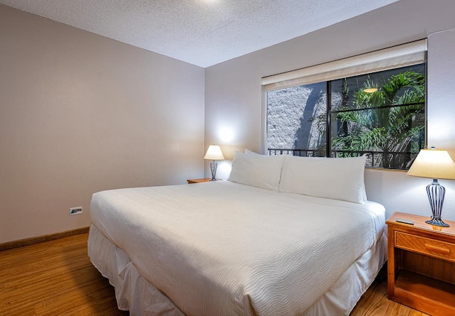 bedroom featuring hardwood / wood-style floors and a textured ceiling