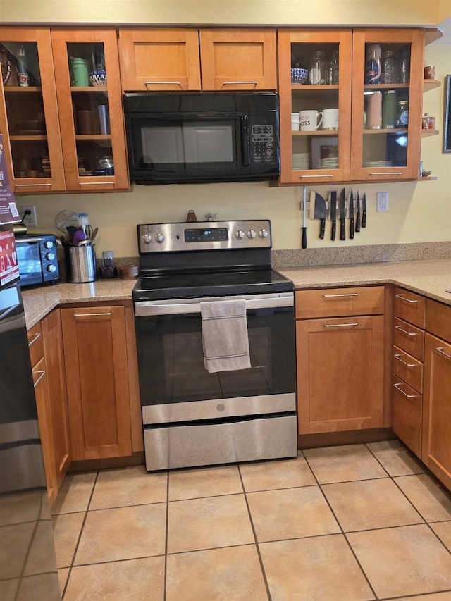 44 Kanani Rd Unit 1-104, Kihei, HI 96753 - kitchen featuring black microwave, electric stove, light tile patterned flooring, and brown cabinetry