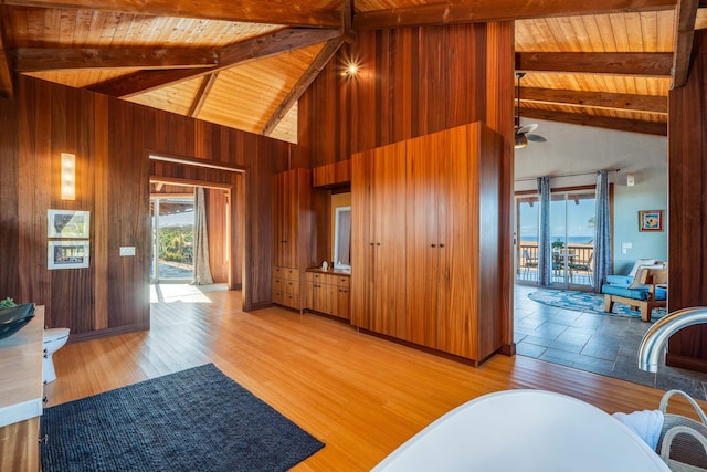 living room with beamed ceiling, wood walls, and wood ceiling