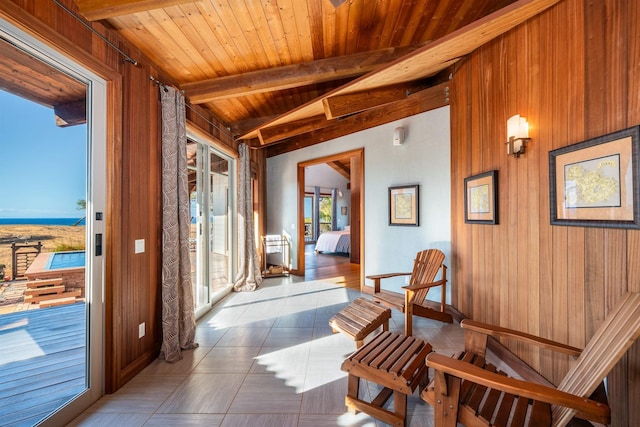 sitting room with lofted ceiling with beams, wooden ceiling, and wooden walls