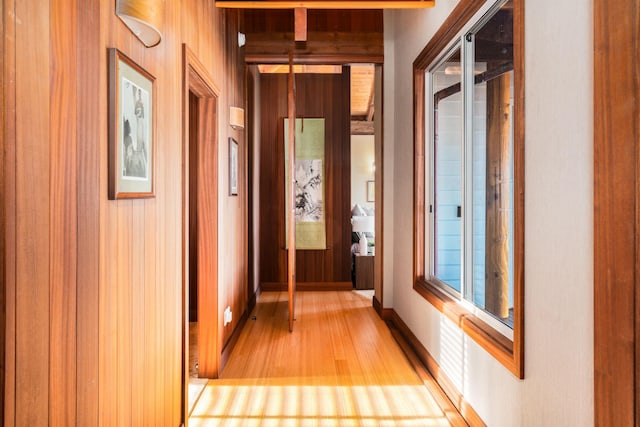 hall featuring wood walls and light wood-type flooring