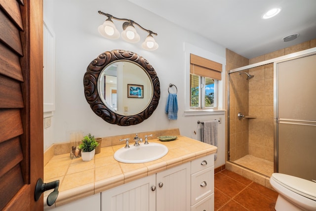 bathroom with tile patterned floors, vanity, toilet, and a shower with shower door