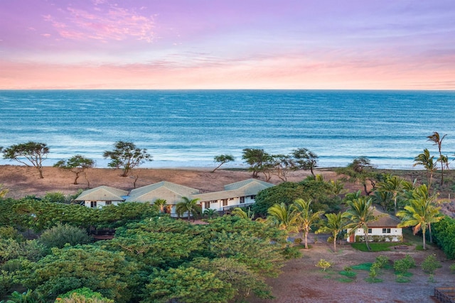 aerial view at dusk featuring a water view