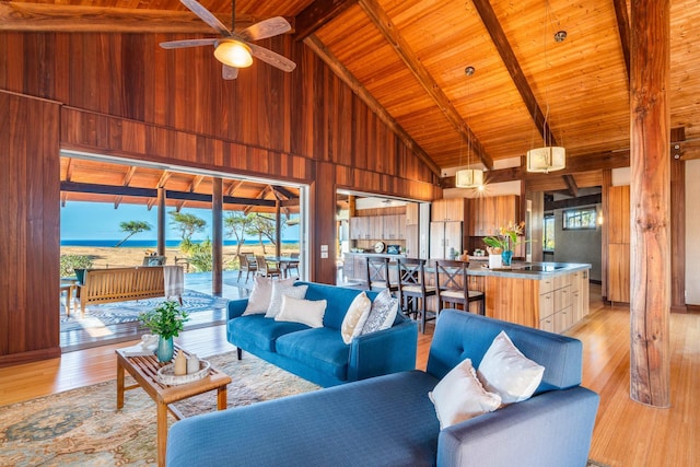 living room with beam ceiling, ceiling fan, light hardwood / wood-style flooring, and high vaulted ceiling