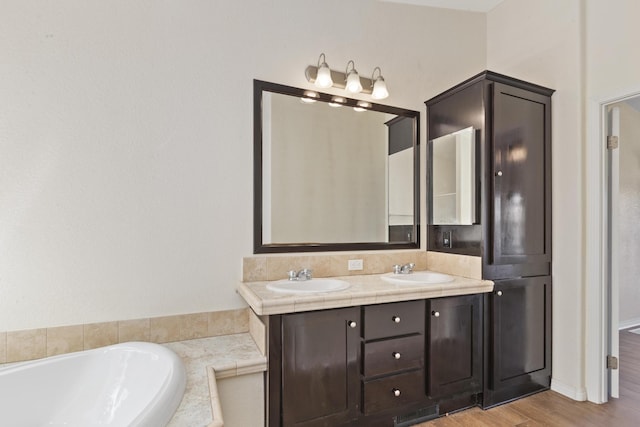 bathroom featuring double vanity, visible vents, a sink, and a garden tub