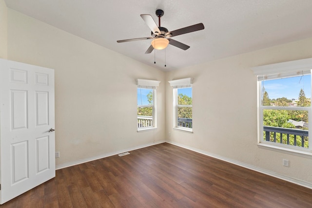 empty room with lofted ceiling, ceiling fan, and dark hardwood / wood-style floors