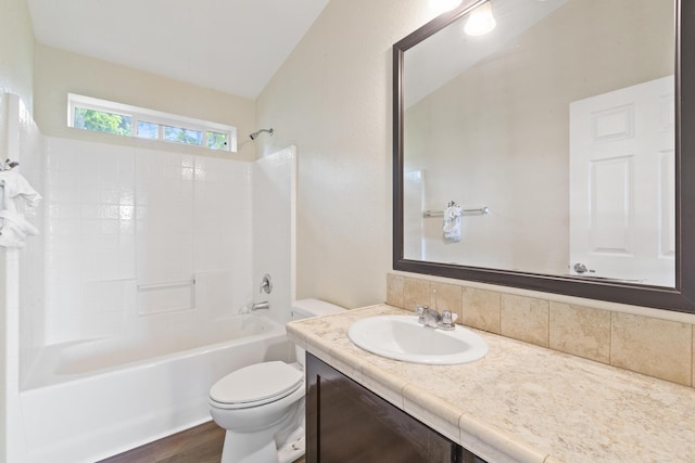 full bath with shower / bath combination, decorative backsplash, wood finished floors, vanity, and toilet