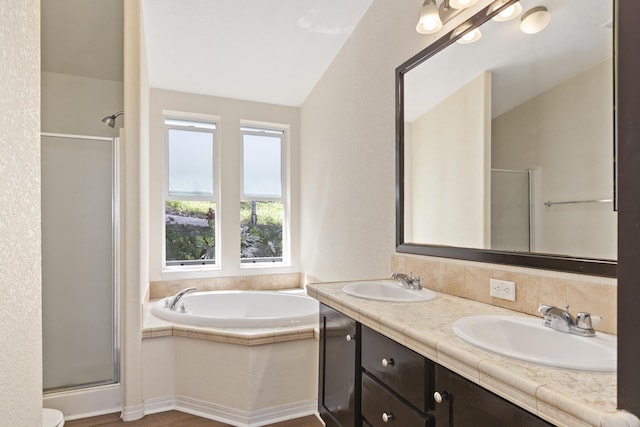 full bathroom with double vanity, a shower stall, a sink, and a bath