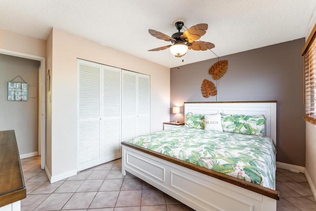 bedroom featuring light tile patterned floors, a textured ceiling, ceiling fan, and a closet