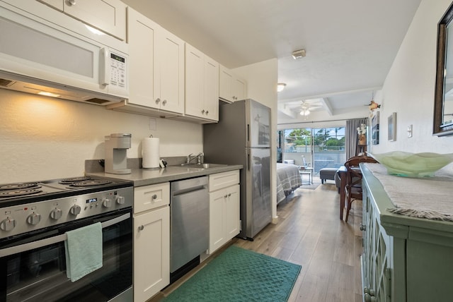 kitchen with white cabinets, ceiling fan, stainless steel appliances, and light hardwood / wood-style floors