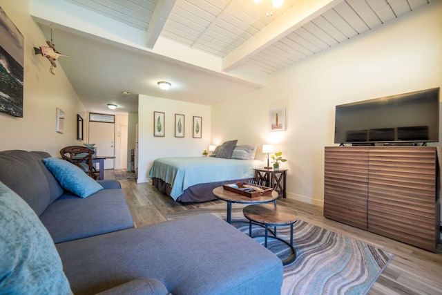 bedroom with hardwood / wood-style floors and beam ceiling