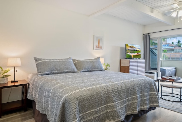 bedroom featuring beamed ceiling, hardwood / wood-style floors, and ceiling fan