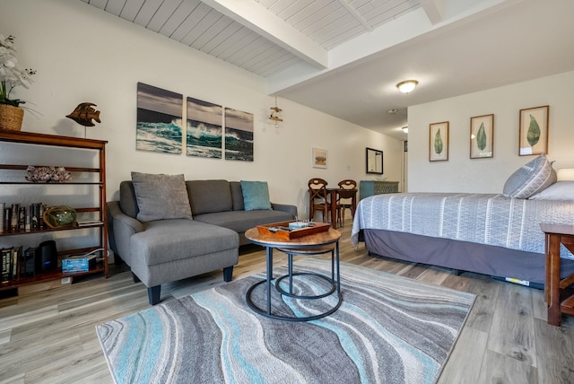 bedroom with beamed ceiling and hardwood / wood-style floors