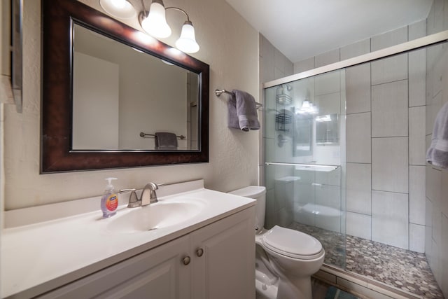 bathroom featuring an enclosed shower, vanity, and toilet