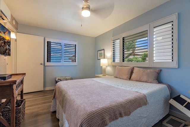 bedroom with baseboards, a wall mounted air conditioner, a ceiling fan, and wood finished floors