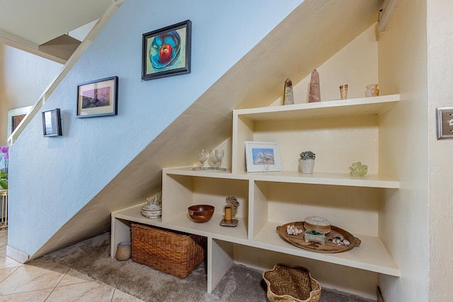stairway with tile patterned floors and a textured wall