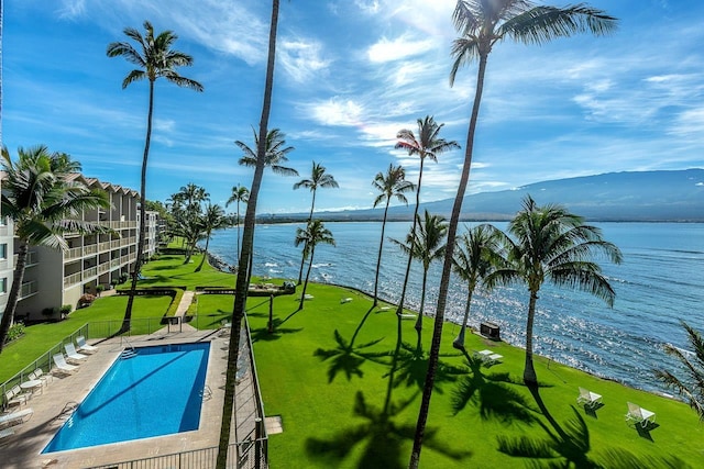community pool featuring a water view and fence