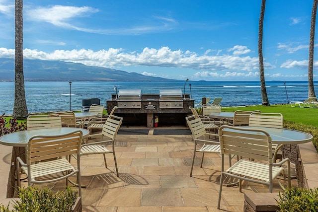 view of patio featuring a water view, grilling area, and outdoor dining space