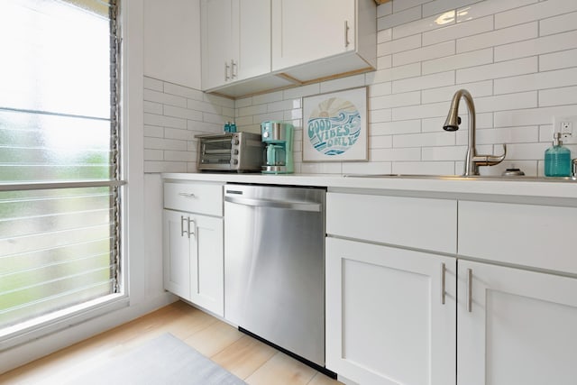 kitchen featuring tasteful backsplash, white cabinets, and stainless steel dishwasher