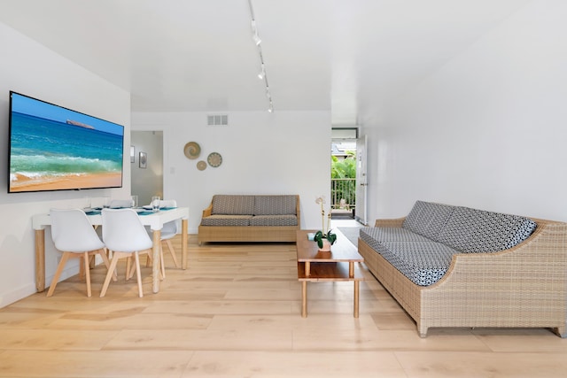 living room featuring light wood-type flooring and rail lighting