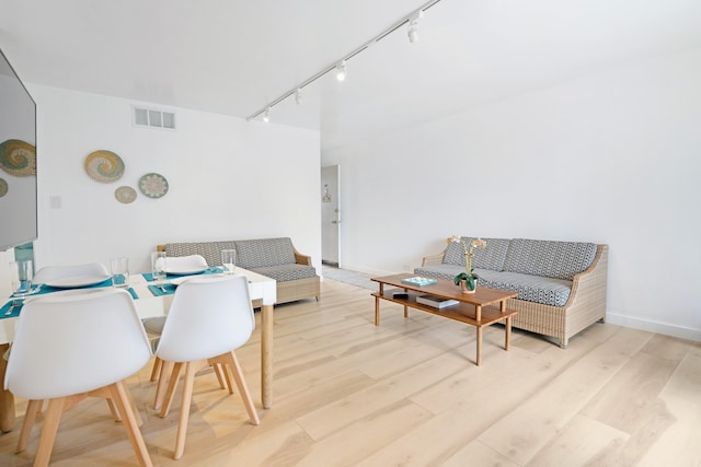 living room with track lighting and light wood-type flooring