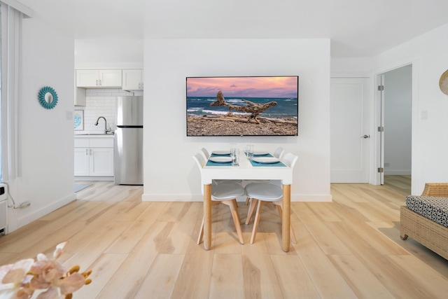 dining room featuring sink and light hardwood / wood-style floors