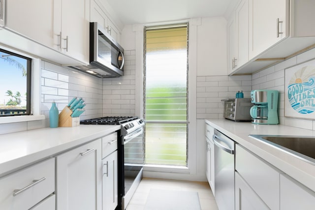 kitchen featuring appliances with stainless steel finishes, tasteful backsplash, and white cabinetry