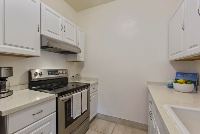 160 Keonekai Rd Unit 11-201, Kihei, HI 96753 - kitchen featuring stainless steel electric range, under cabinet range hood, white cabinetry, and baseboards