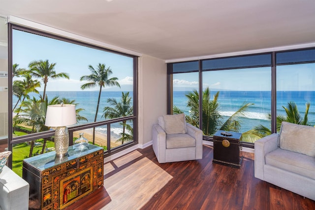 sunroom featuring a water view