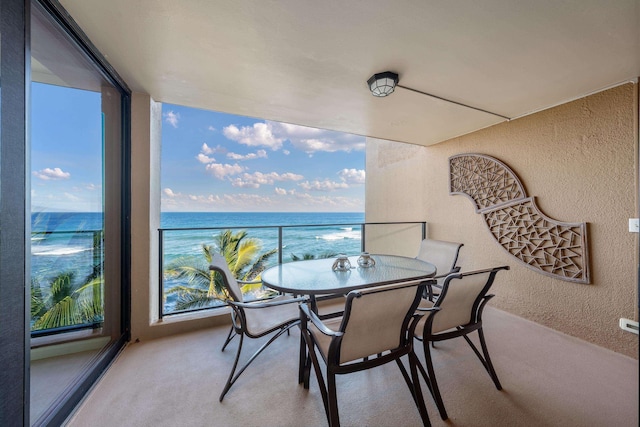 balcony with a water view and outdoor dining area